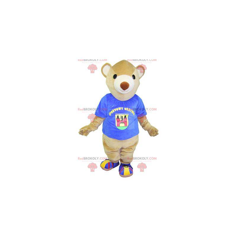 Beige beer mascotte met een blauw t-shirt. Teddybeer mascotte -