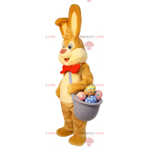 Mascotte de lapin de Pâques avec un panier d'œufs en chocolat
