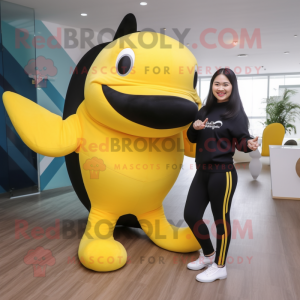 Yellow Killer Whale mascot costume character dressed with a Yoga Pants and Mittens