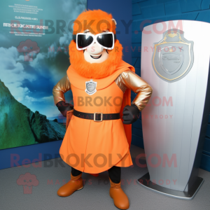 Orange Celtic Shield mascot costume character dressed with a Rash Guard and Sunglasses
